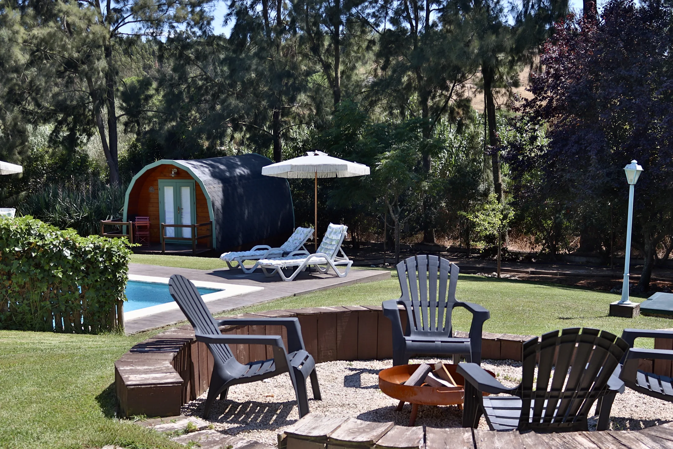 Bungalow, piscina e zona de fogueira durante o dia